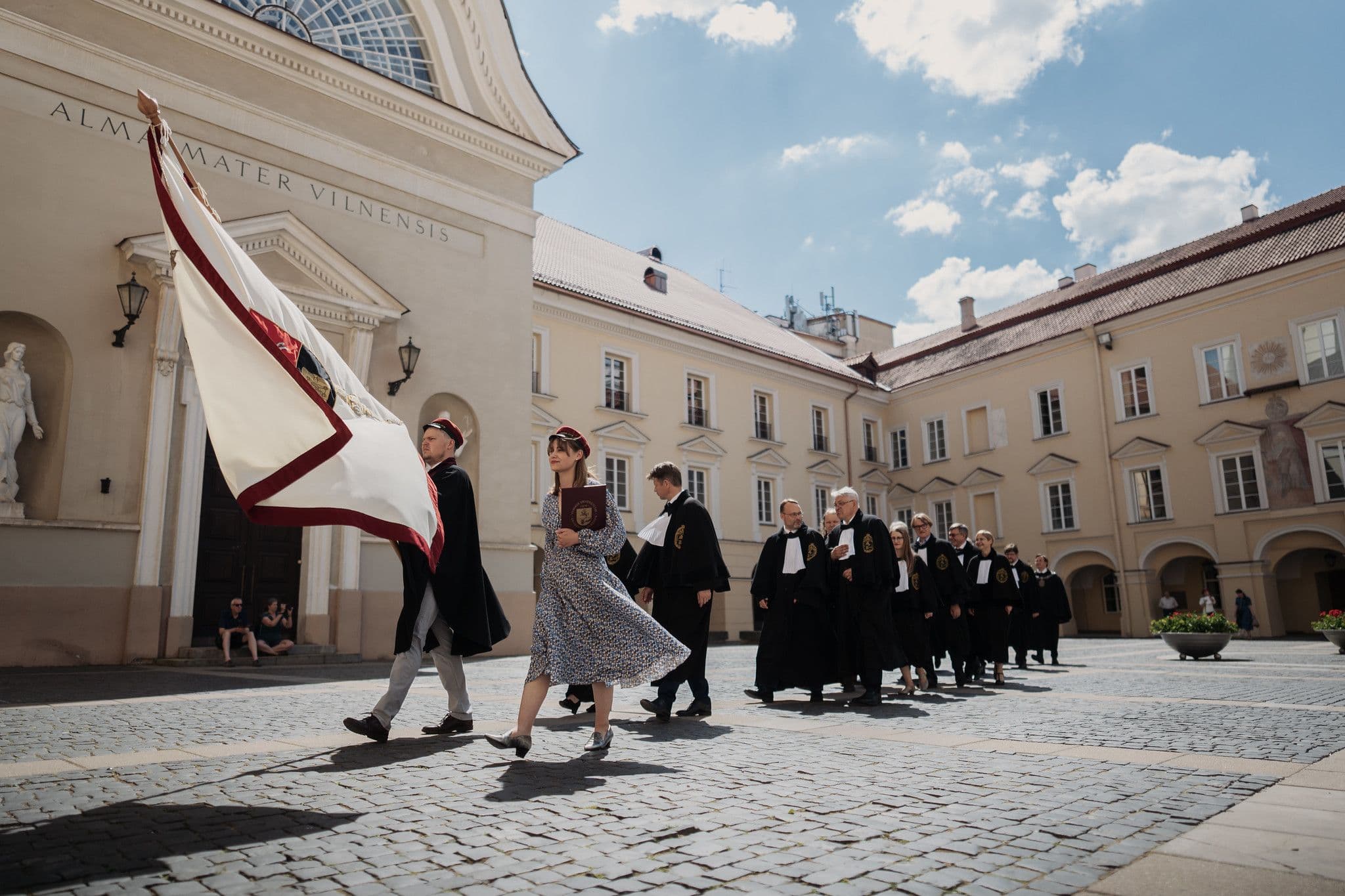 Iškilminga VU eisena su priekyje nešama vėliava