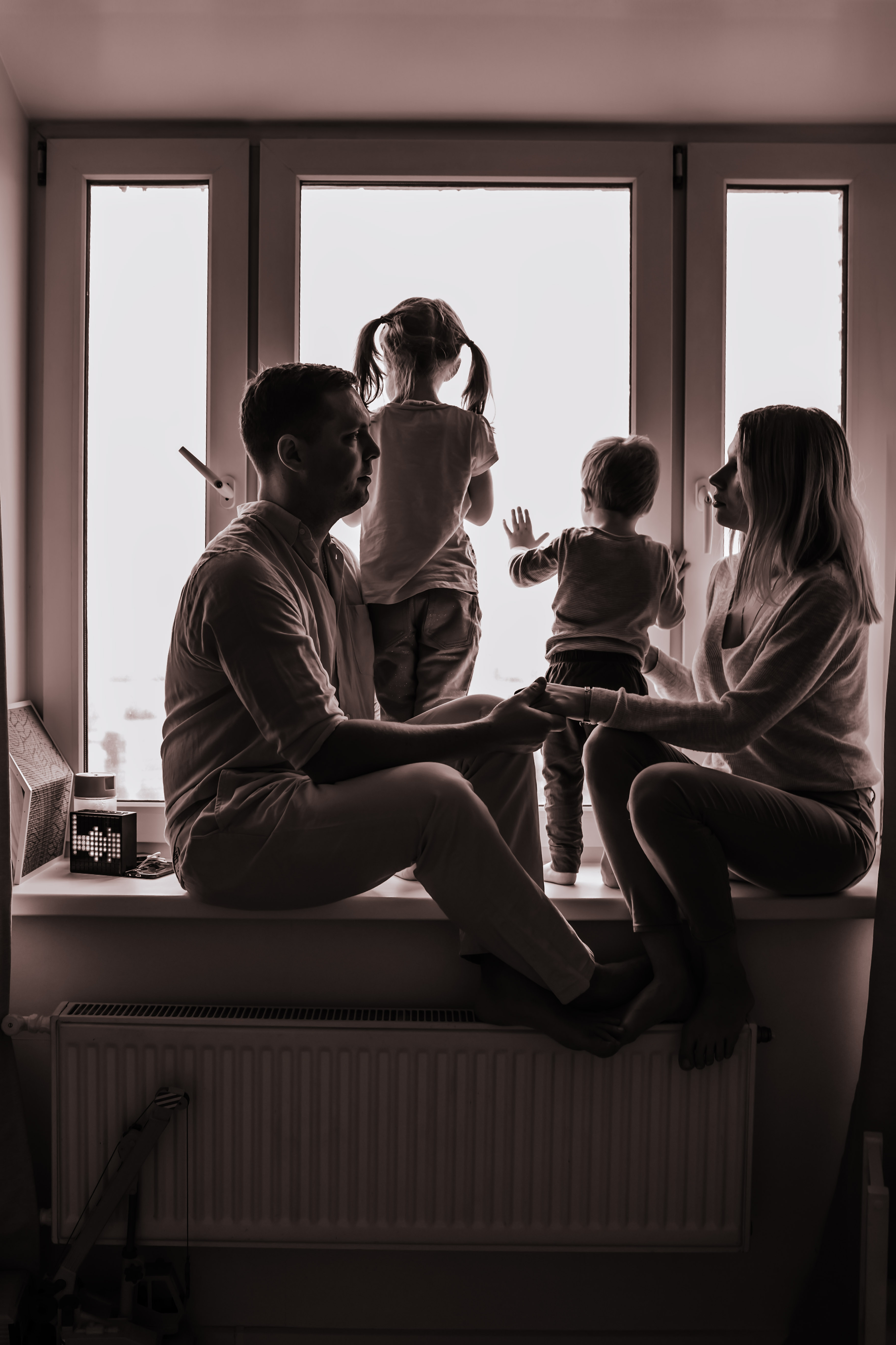 black white portrait caucasian family looking out window