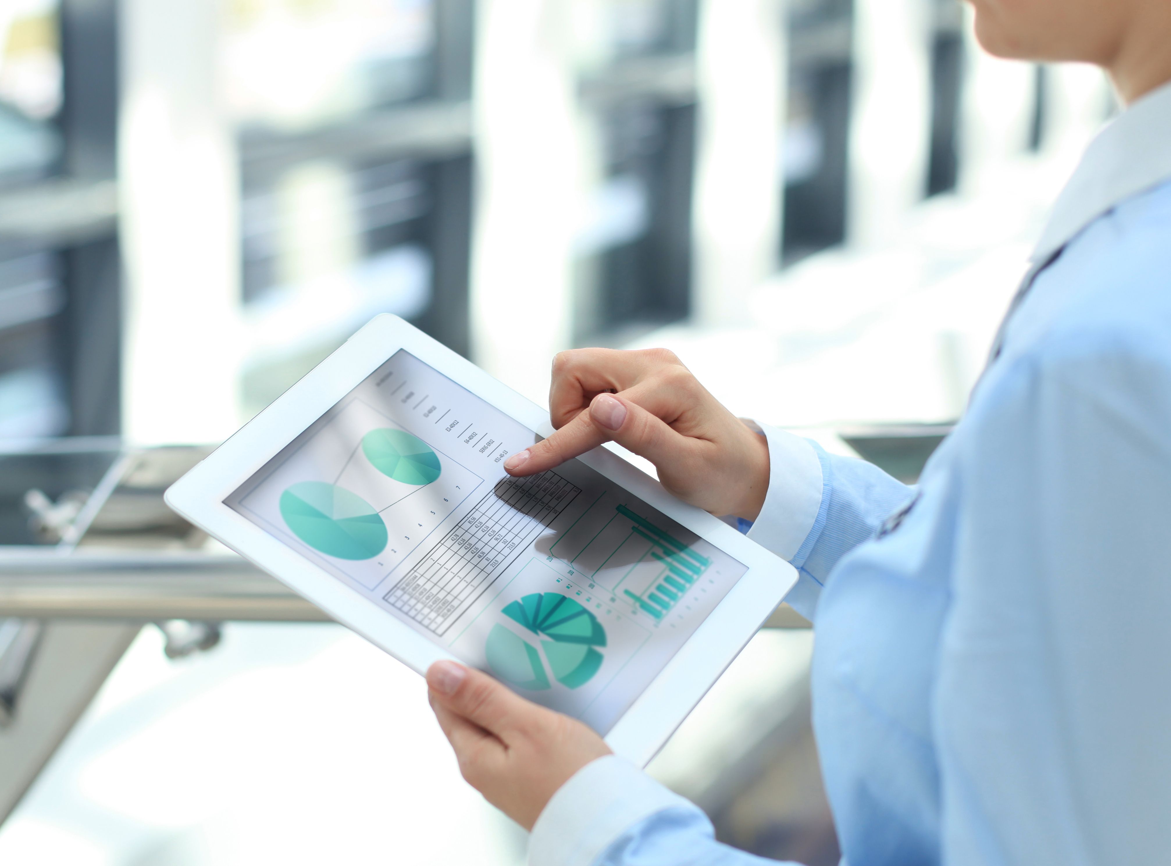 Business person analyzing financial statistics displayed on the tablet screen